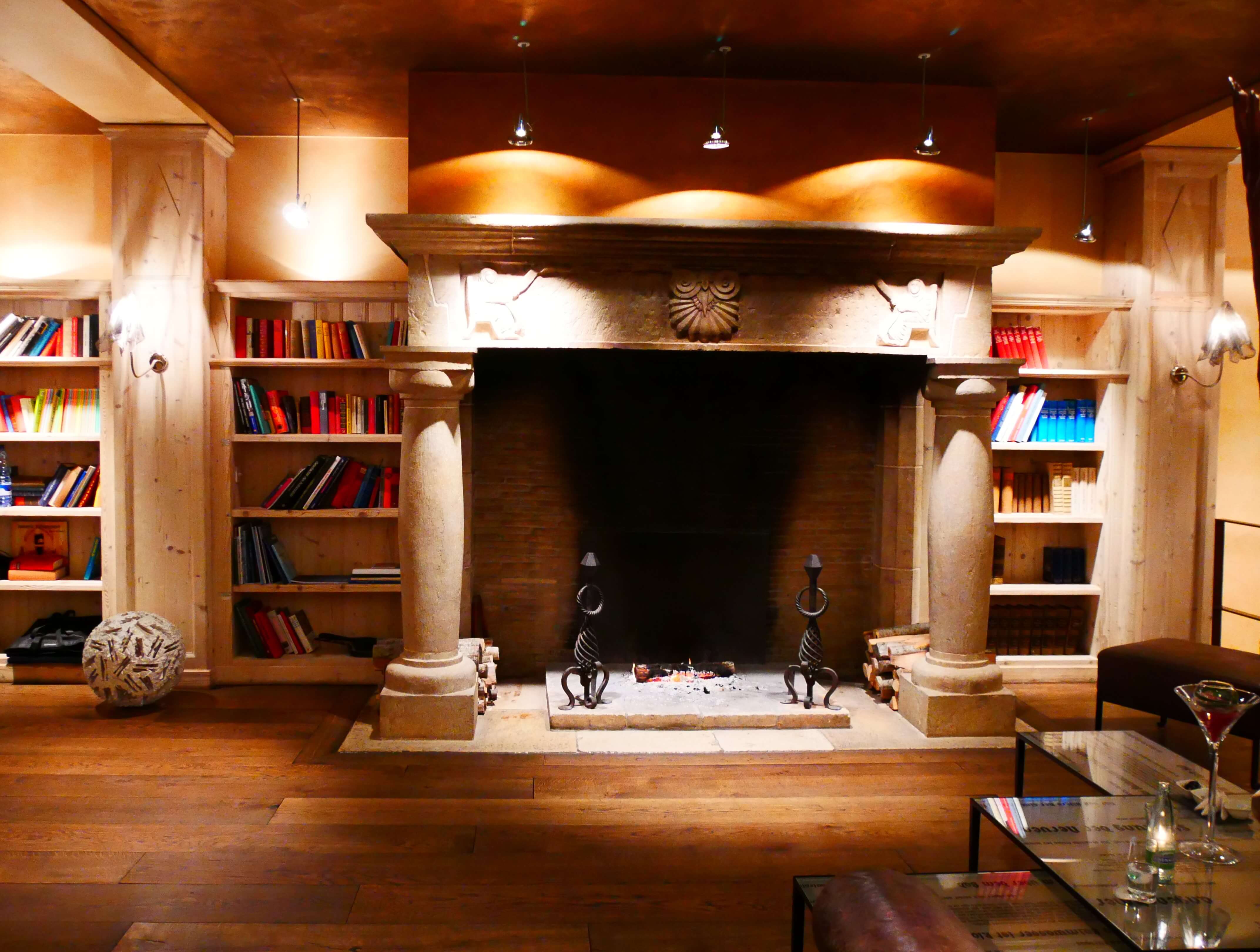 La grande cheminée du bar du Lenkerhof pour un séjour romantique en Suisse